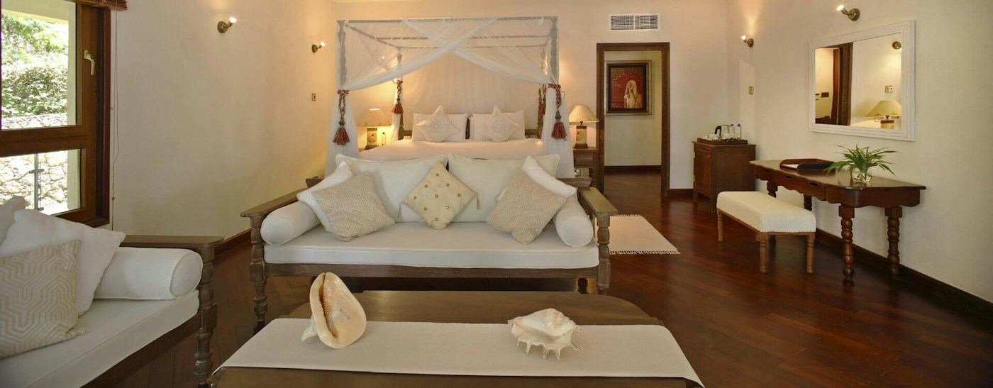 Spacious guest bedroom with a seating area at Almanara