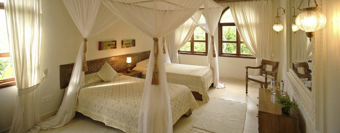 Twin four-poster beds in a guest bedroom at Almanara