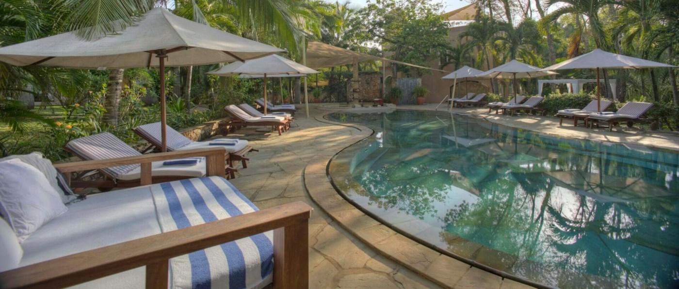 Poolside sun loungers in the tropical gardens at Almanara