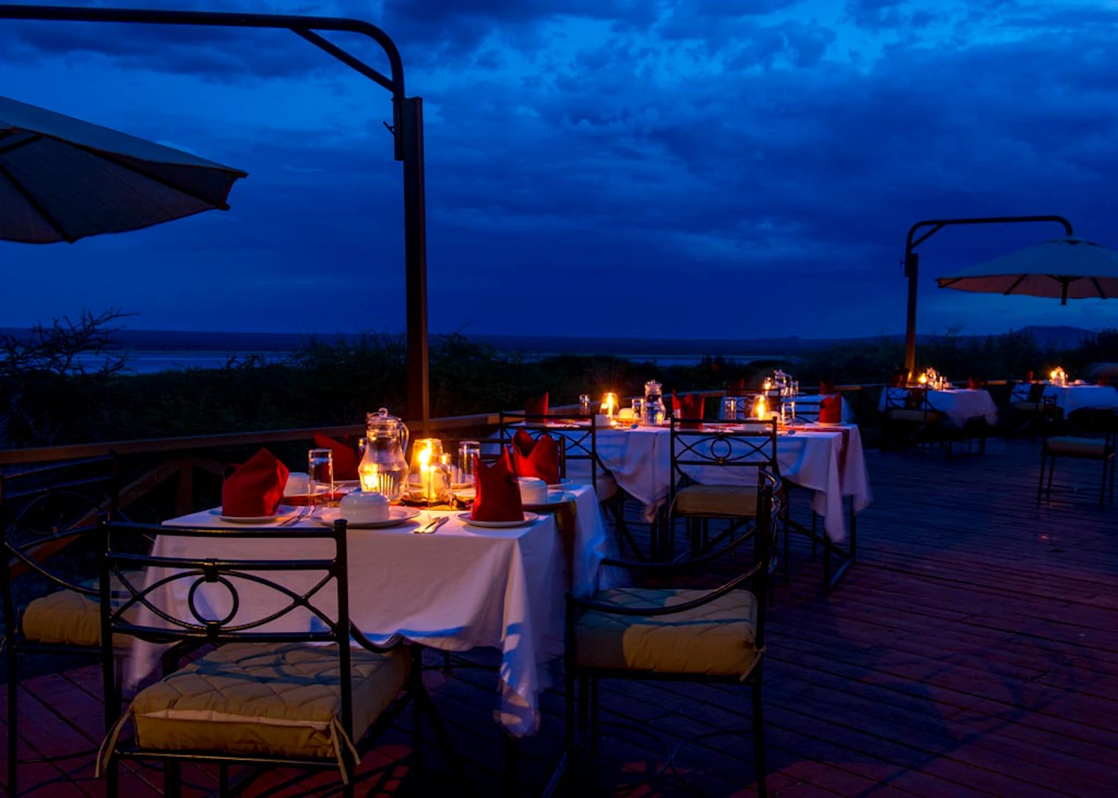 Outdoor dining terrace in the evening at Burunge Tented Lodge