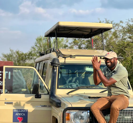 A Brilliant Africa guide beside a safari vehicle in Tanzania