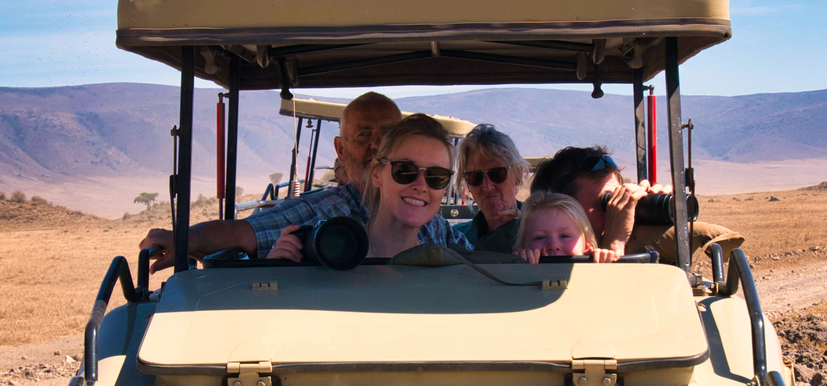Family enjoying their first safari from an open vehicle