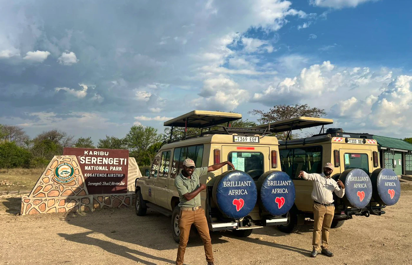 Two adult safari guides with Brilliant Africa vehicles at Serengeti National Park