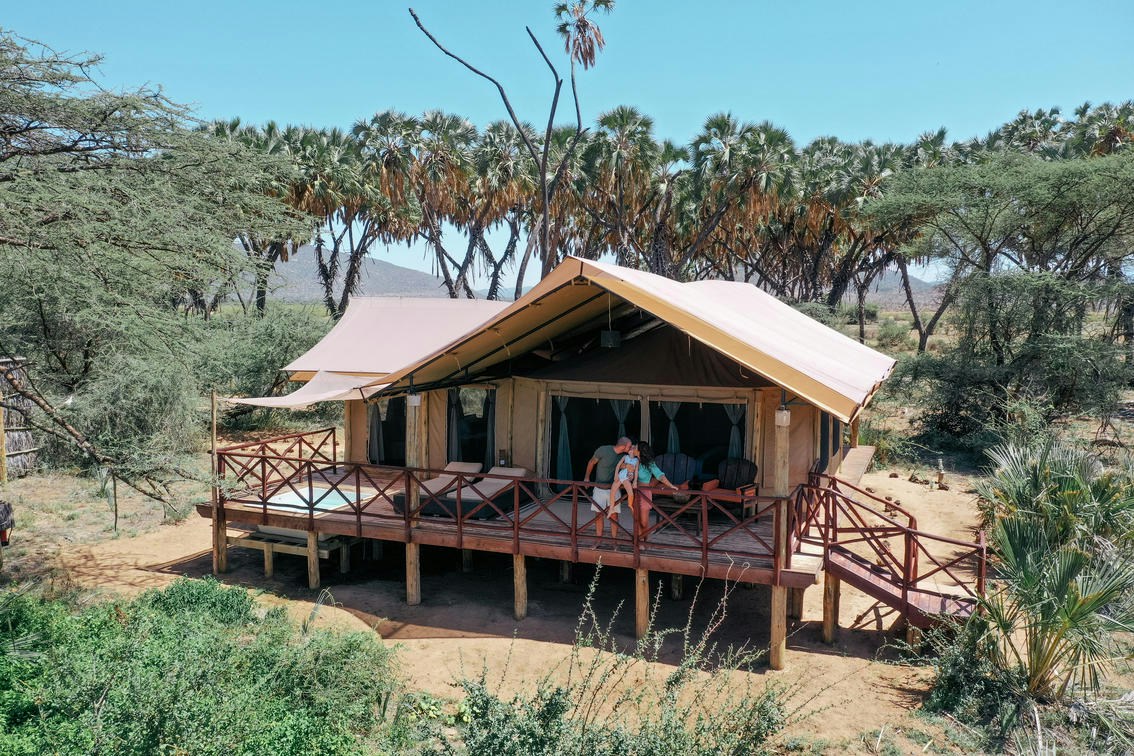 Guest tent and deck beneath riverine trees at Elephant Bedroom Camp