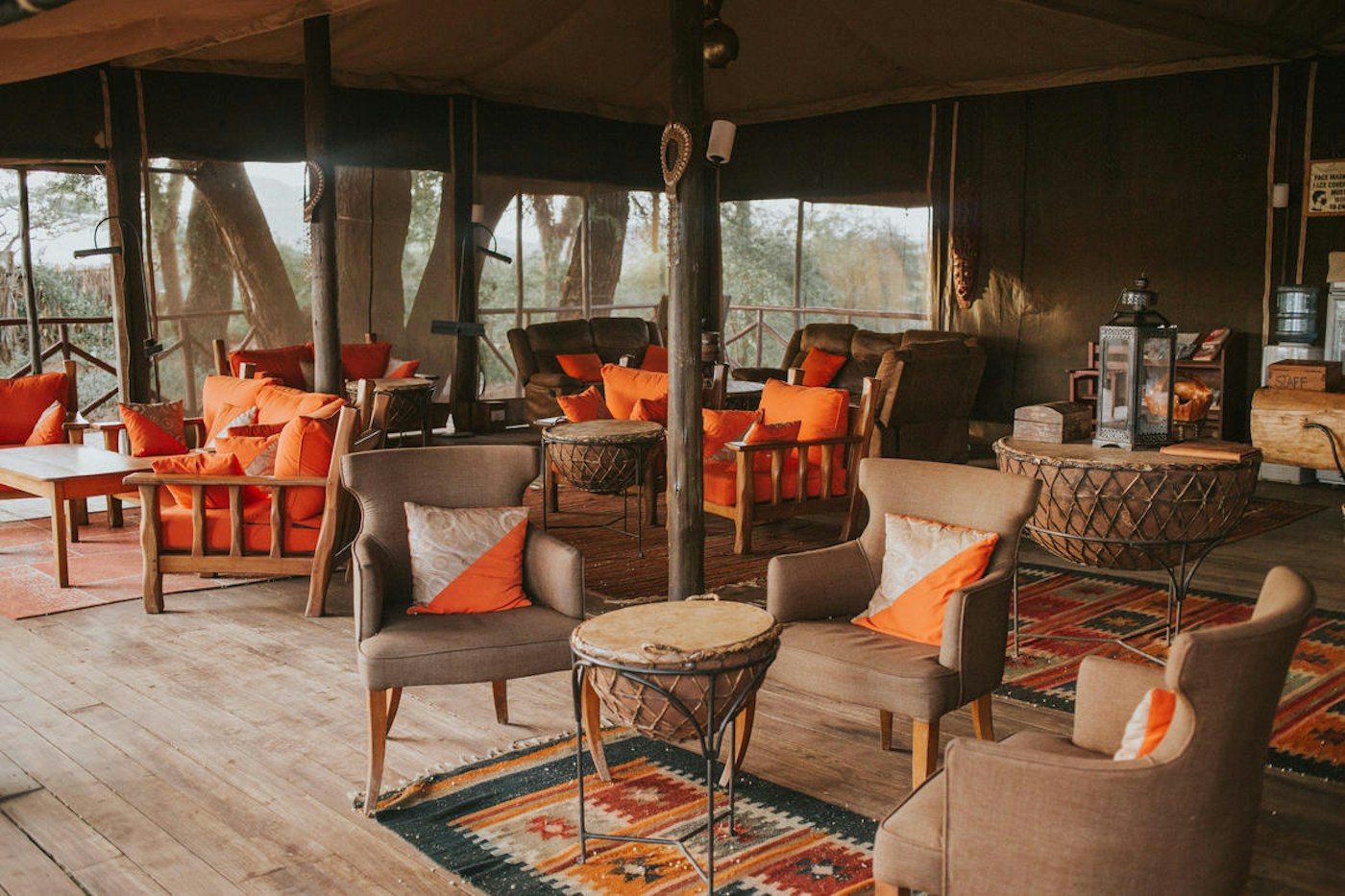 Main lounge with armchairs and warm safari colours at Elephant Bedroom Camp