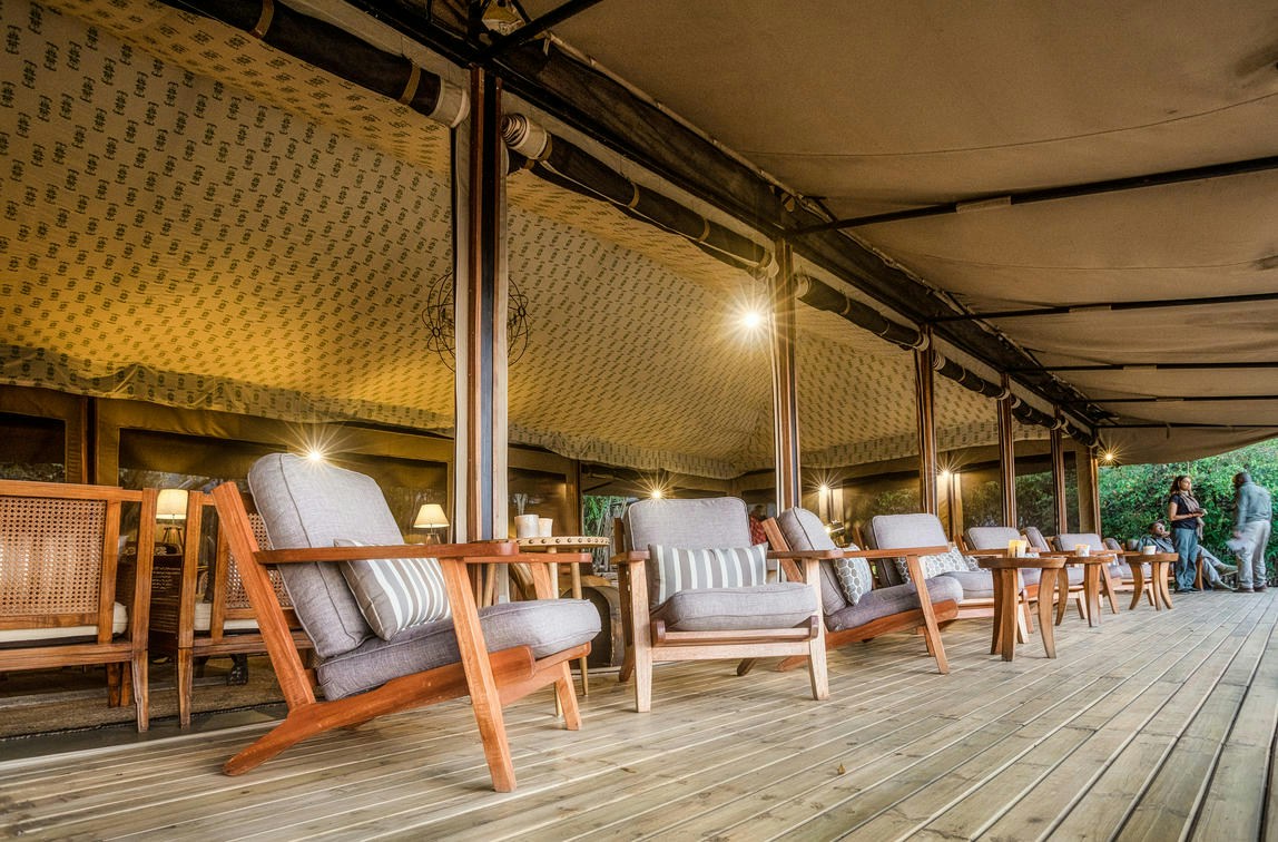 Shaded veranda seating outside the main camp tent at Entim Mara Camp