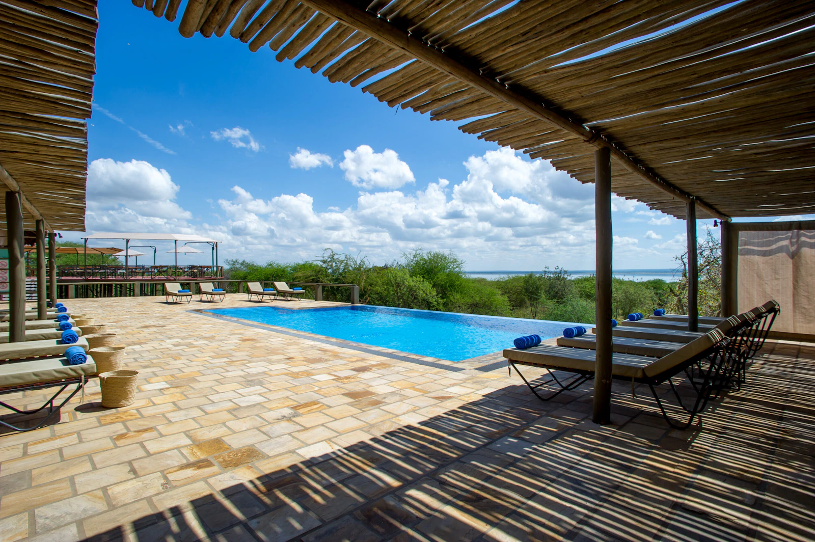 Shaded poolside seating at Burunge Tented Lodge