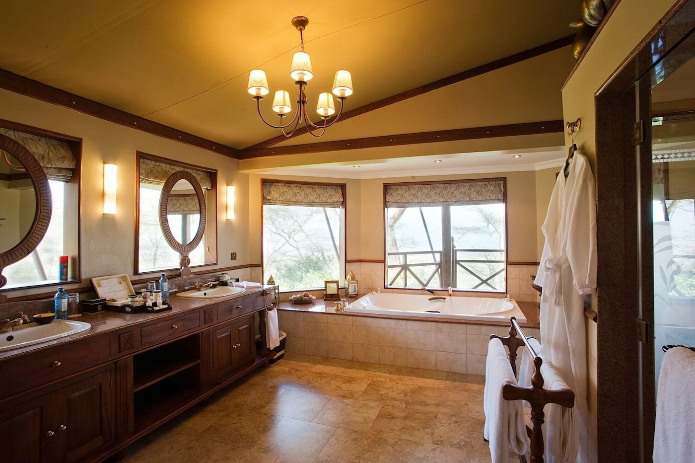 Guest bathroom with a bath and twin basins at Lake Elmenteita Serena Camp
