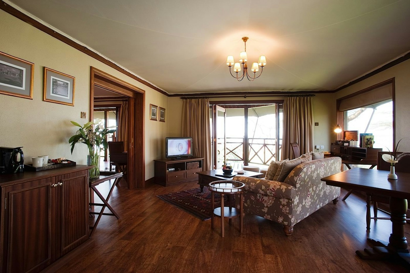 Guest suite with a bed, desk and television at Lake Elmenteita Serena Camp