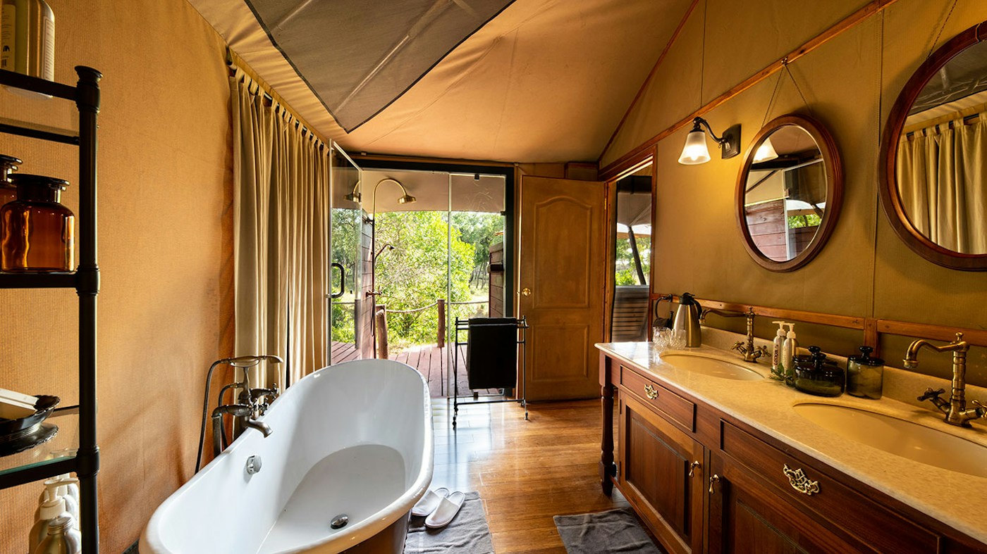 Guest bathroom with a freestanding bath and twin basins at Sand River Mara