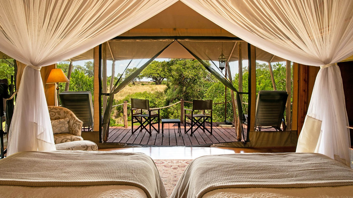 Twin guest tent opening onto a private veranda at Sand River Mara