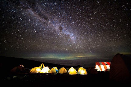 Night sky above glowing tents on Kilimanjaro hike in Tanzania